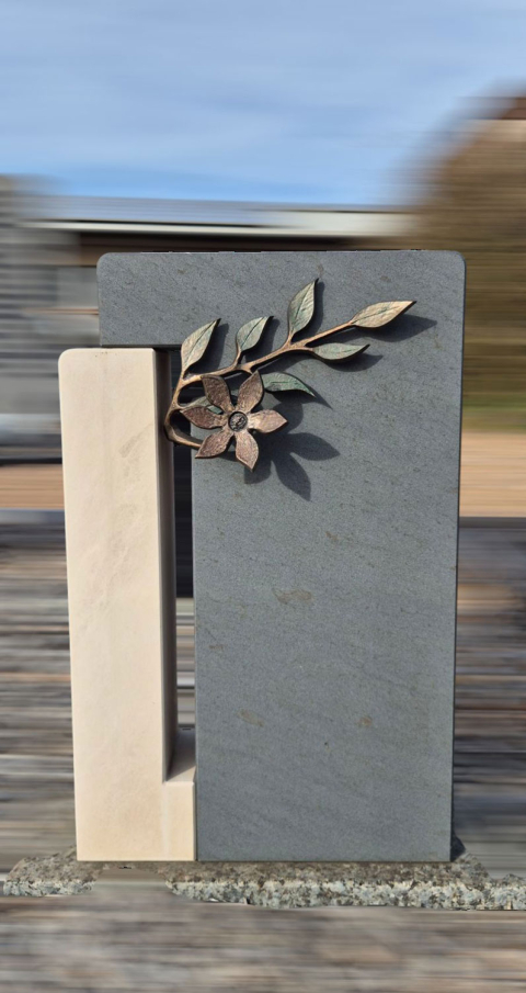 Mehrfarbige Grabsteine mit Metallblumen