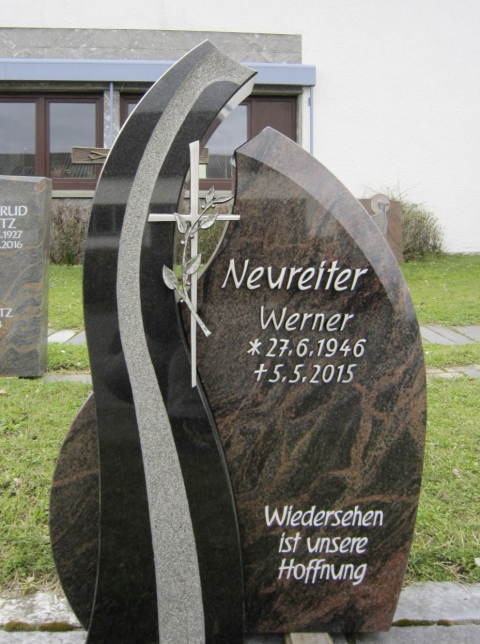 Individuell gestalteter Grabstein mit verschiedenen Elementen