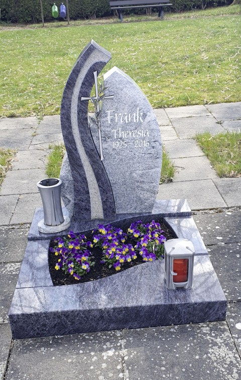 Urnengrabstein mit verschiedenen Steinelementen und Metallkreuz