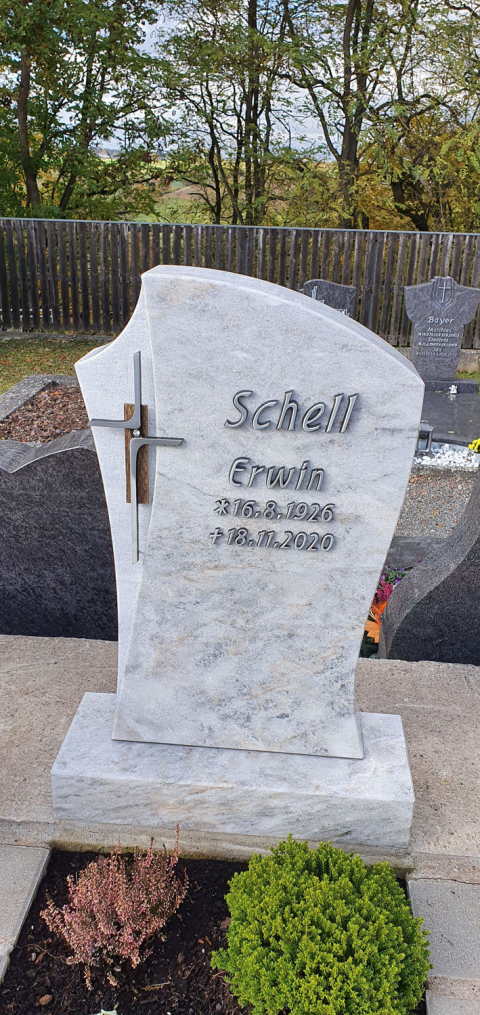 Heller Urnengrabstein mit Metallkreuz