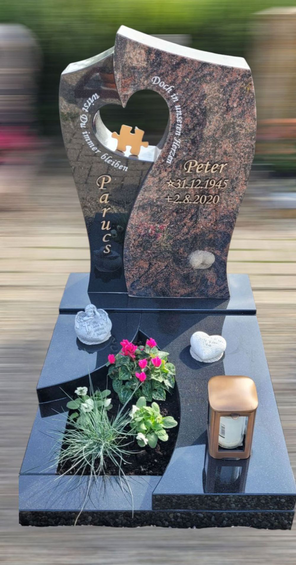 Grabstein mit unterschiedlichen Steinen und einer Ausspaarung in Herzform