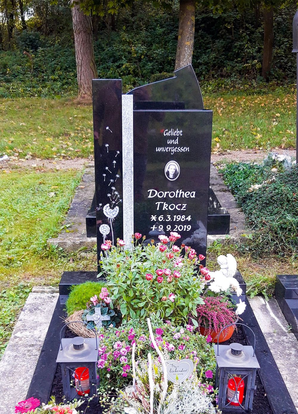 Einzelgrabstein mit dekorativen Elementen auf dem Friedhof